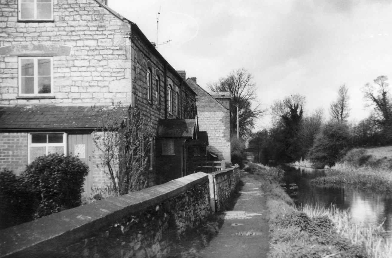 Canal Cottages on the canal bank with Jacob's Cottage beyond.